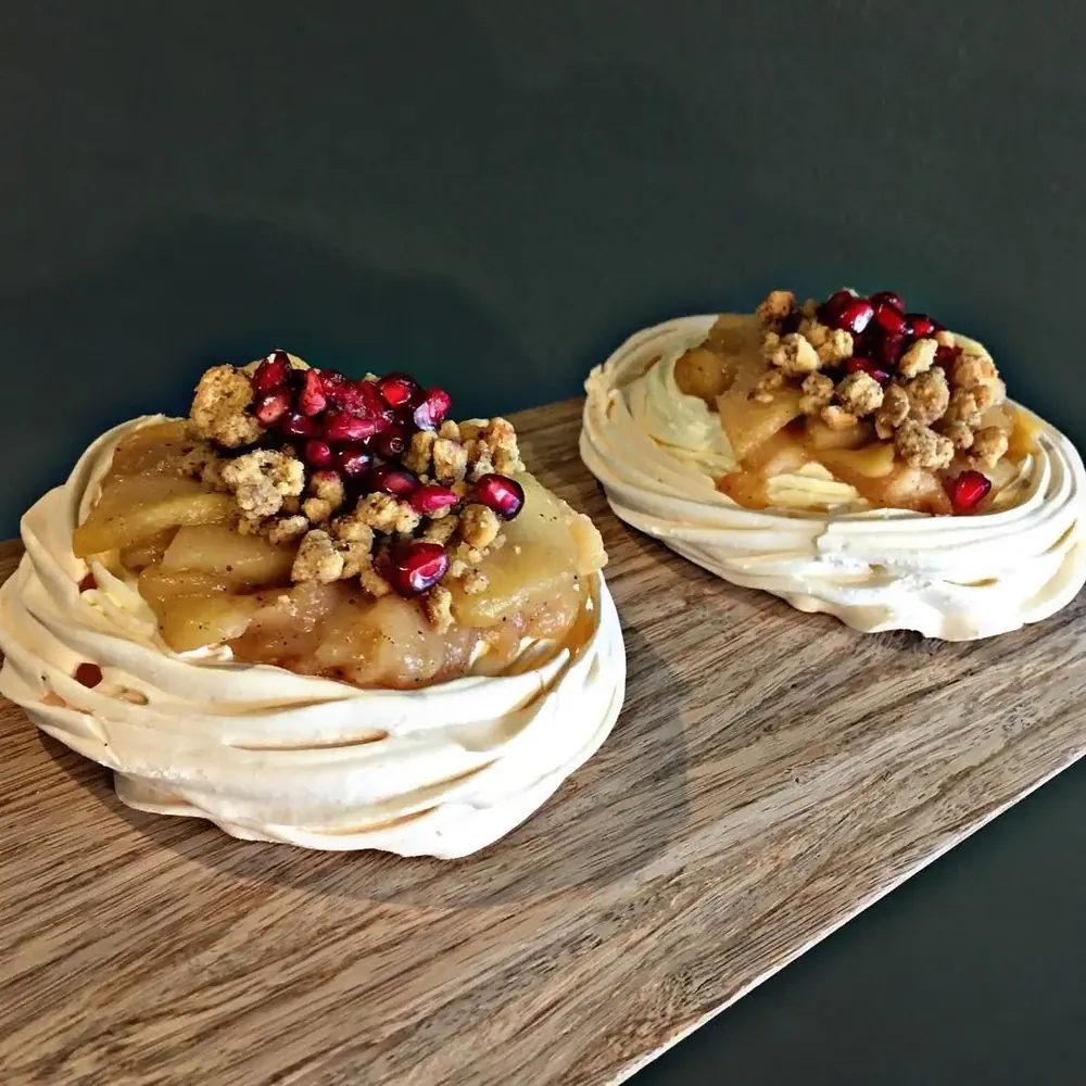 Pavlova s karamelem a ořechy na dřevěném prkénku